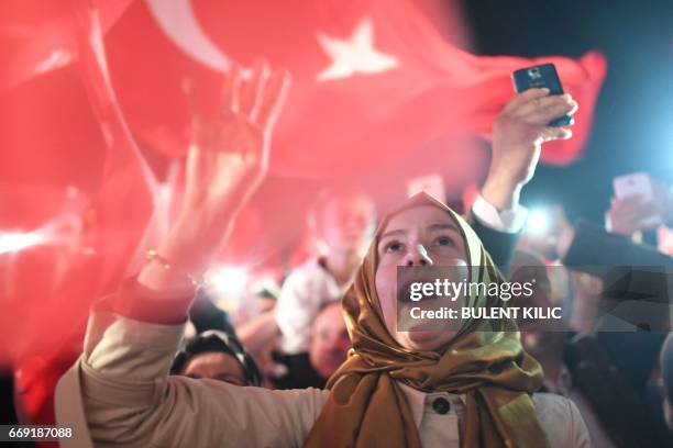 Woman flashes a four finger sign called "the rabia sign" as she celebrates and greets Turkish president during his speech at the conservative Justice...