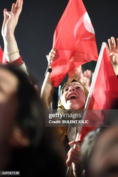 Woman flashes a four finger sign called "the rabia sign" as she celebrates and greets Turkish president during his speech at the conservative Justice...