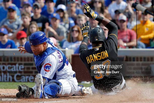 Alen Hanson of the Pittsburgh Pirates scores as Willson Contreras of the Chicago Cubs is unable to keep his foot on home plate during the eighth...