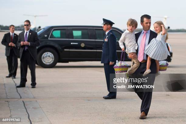 Donald Trump, Jr. Holds his daughter Chloe and son Donald Trump III as they walk off Air Force One at Andrews Air Force Base, MD, April 16, 2017. /...