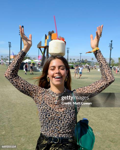 Festivalgoer poses with a coconut drink during Coachella Valley Music And Arts Festival at Empire Polo Club on April 16, 2017 in Indio, California.