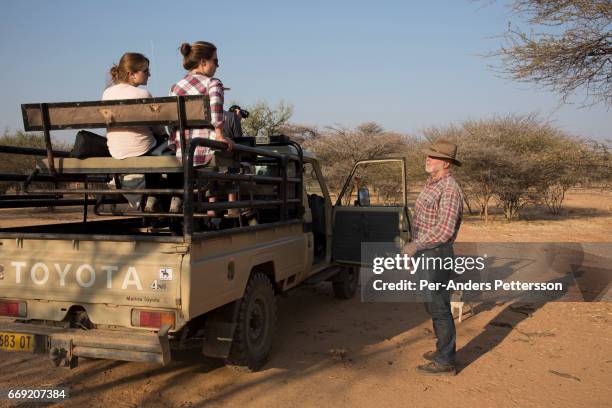 German farmer W.G. Diekmann talks to German tourists during a game drive on his land, a massive 20,000 hectares farm named Hamakari on August 14,...