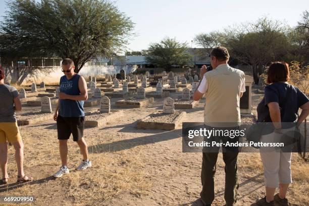 German tourists visit a German & Herero grave monuments seen at a cemetery on August 11, 2016 in Okahandja, Namibia. The area was the venue for...