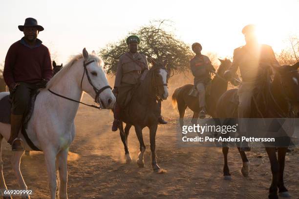 Herero groups parade in traditional military uniforms on horseback during a march when commemorating fallen chiefs killed in battles with Germans on...