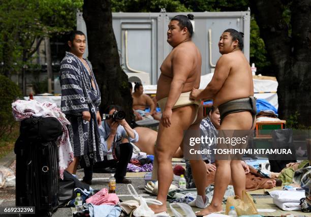 Sumo wrestlers prepare ahead of a "honozumo," a ceremonial sumo exhibition, on the grounds of Yasukuni Shrine in Tokyo on April 17, 2017. Sumo's top...