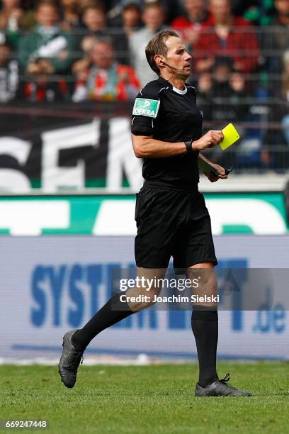 Referee Sascha Stegemann with the yellow card during the Second Bundesliga match between Hannover 96 and Eintracht Braunschweig at HDI-Arena on April...