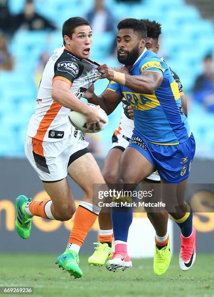 Mitch Moses of the Tigers is tackled by Michael Jennings of the Eels during the round seven NRL match between the Parramatta Eels and the Wests...