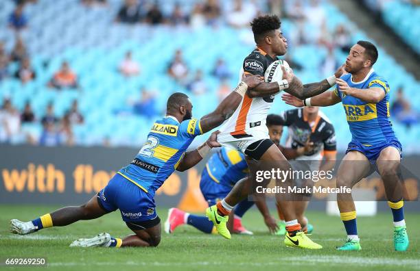 Kevin Naiqama of the Tigers is tackled during the round seven NRL match between the Parramatta Eels and the Wests Tigers at ANZ Stadium on April 17,...