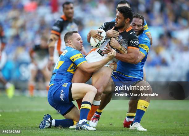 David Nofoaluma of the Tigers is tackled during the round seven NRL match between the Parramatta Eels and the Wests Tigers at ANZ Stadium on April...