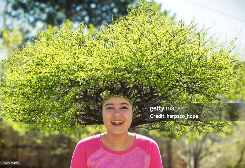 Smiling girl with a tree for hair.
