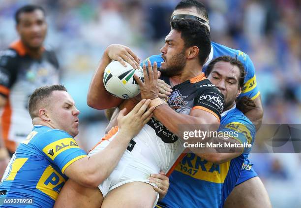 David Nofoaluma of the Tigers is tackled during the round seven NRL match between the Parramatta Eels and the Wests Tigers at ANZ Stadium on April...