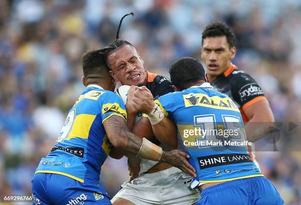 Sauaso Sue of the Tigers is tackled during the round seven NRL match between the Parramatta Eels and the Wests Tigers at ANZ Stadium on April 17,...