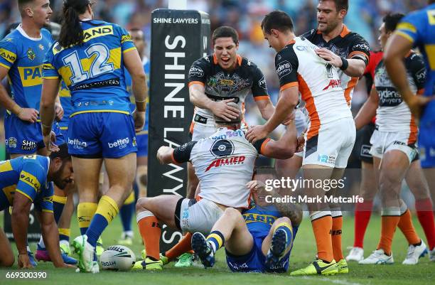 Matt Mcllwrick of the Tigers celebrates scoring a try with team mates during the round seven NRL match between the Parramatta Eels and the Wests...