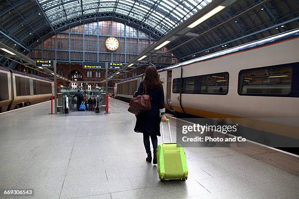 woman with suitcase in a train station - station london st pancras international stockfoto's en -beelden