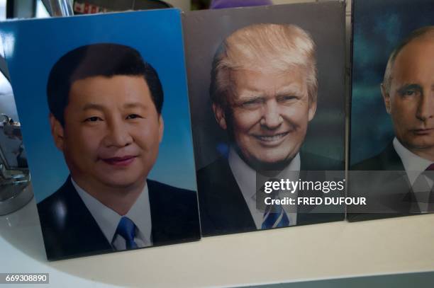 Frames of Chinese President Xi Jinping, US President Donald Trump and Russian President Vladimir Putin are display in a photo shop in Beijing on...