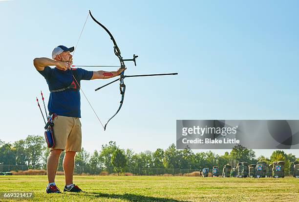 archery competition bow full length - bow arrow stock-fotos und bilder