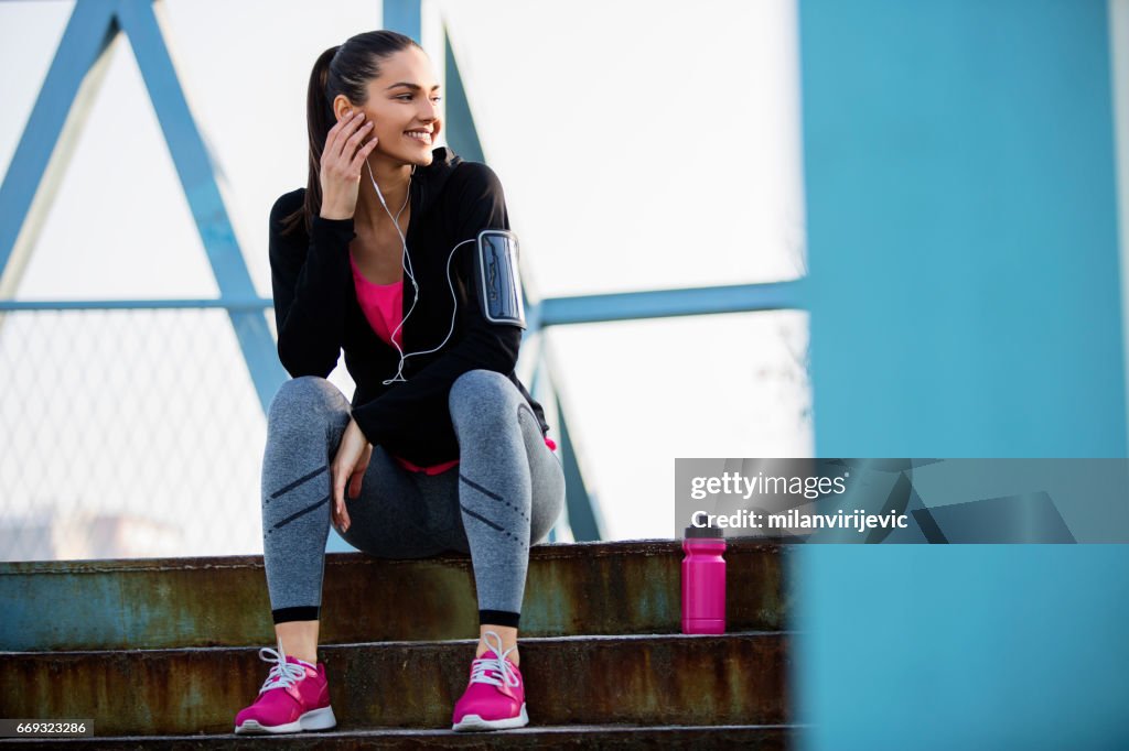 Young female sitting at stairs after running