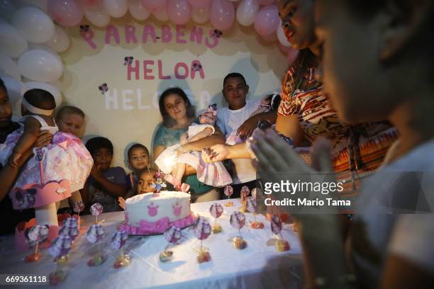 Mother Raquel Barbosa and father Marcello hold twins Heloisa and Heloa, both born with microcephaly, at their one-year birthday party on April 16,...