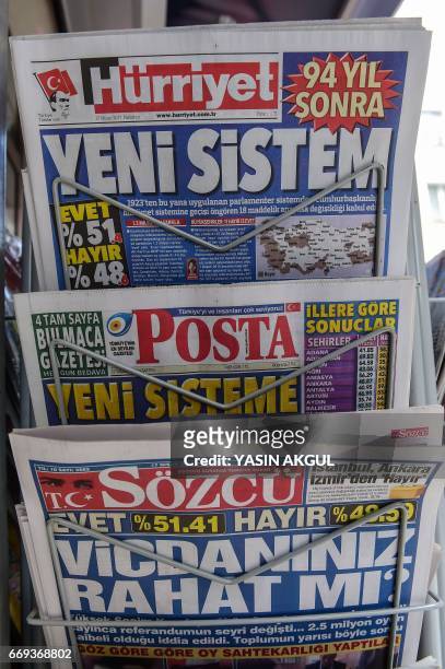 This picture taken in Istanbul on April 17 shows the front pages of Turkish newspapers bearing headlines after referendum : Hurriyet with a headline...