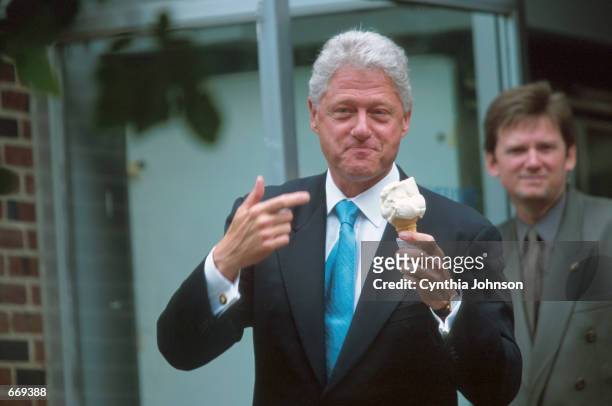 President Bill Clinton enjoys his ''Peachy Paterno'' ice cream cone outside the Creamery store as his aides surround him during a stop on the Campus...