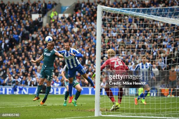 Jake Buxton of Wigan heads clear under pressure from Glenn Murray of Brighton during the Sky Bet Championship match between Brighton & Hove Albion...