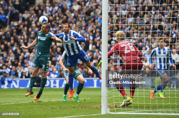 Jake Buxton of Wigan wins a header with Glenn Murray of Brighton and Hove Albion during the Sky Bet Championship match between Brighton and Hove...