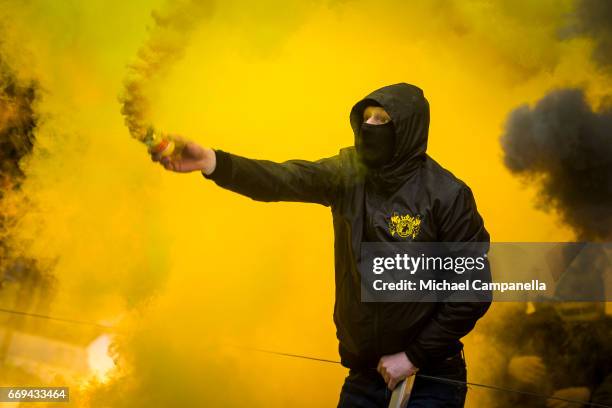 Fan of AIK lights a smoke bomb during an Allsvenskan match between AIK and Hammarby IF at Friends arena on April 17, 2017 in Solna, Sweden.