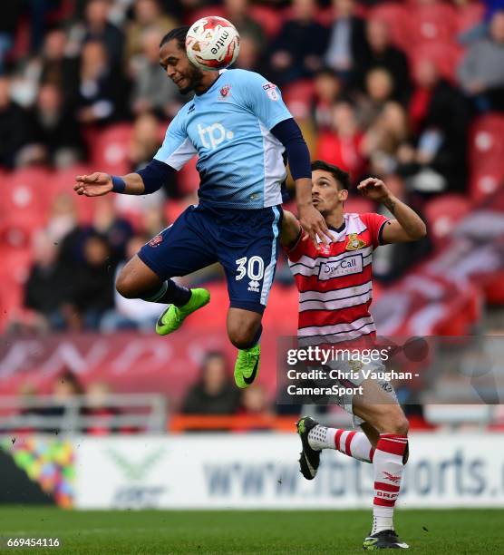 Blackpool's Nathan Delfouneso beats Doncaster Rovers' Niall Mason to a high ball during the Sky Bet League Two match between Doncaster Rovers and...