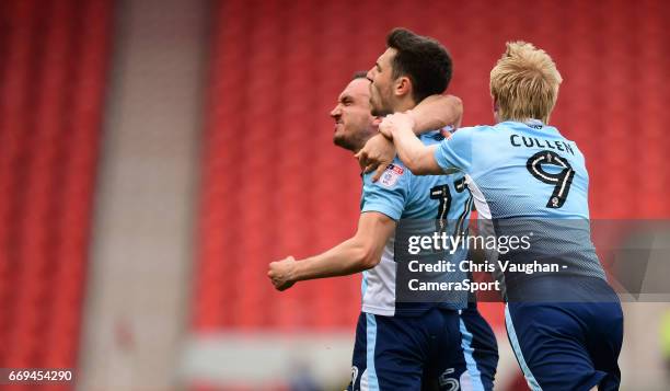 Blackpool's Jordan Flores, centre, celebrates scoring the opening goal from the penalty spot with team-mates Tom Aldred, left, and Mark Cullen during...