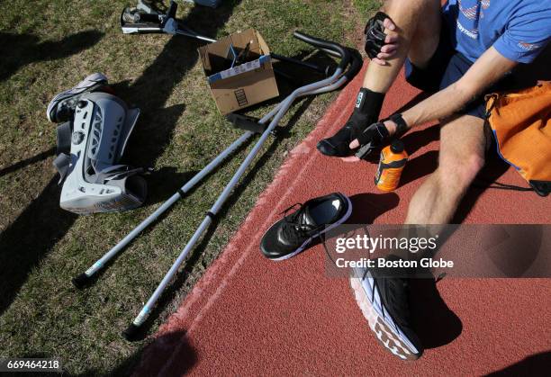 Alain Ferry works out with a walking boot, various crutches and a stability brace at McCurdy Track in Boston's Allston neighborhood on Apr. 13, 2017....