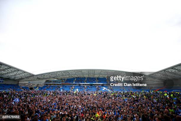 Brighton & Hove Albion fans celebrate on the pitch after their team's victory in the Sky Bet Championship match between Brighton & Hove Albion and...