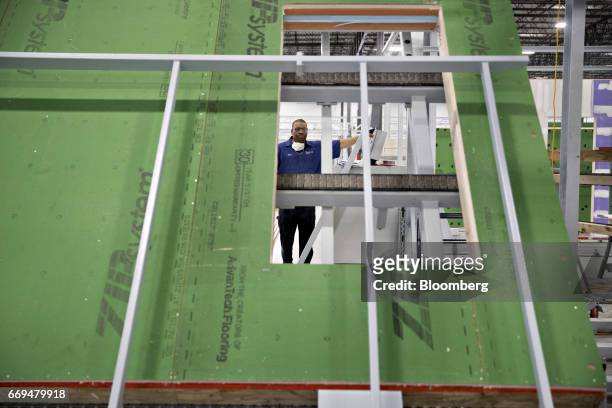 An employee moves a wall upright in the drywall finishing area of the Blueprint Robotics facility in Baltimore, Maryland, U.S., on Tuesday, April 10,...