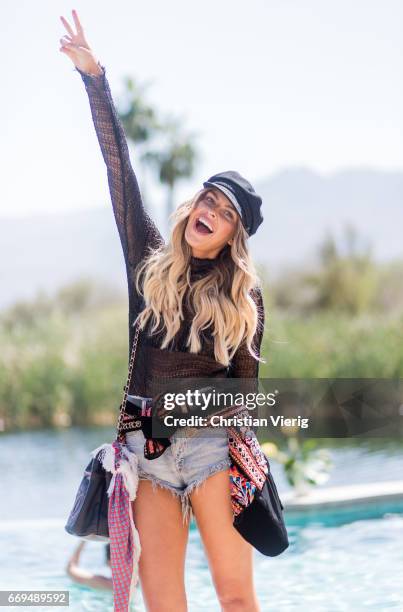 Elle Ferguson wearing a flat cap, denim shorts at the Revovle Festival during day 3 of the 2017 Coachella Valley Music & Arts Festival Weekend 1 on...
