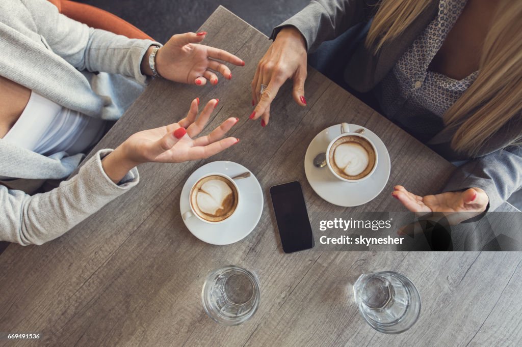 Boven weergave van onherkenbaar zakenvrouwen bespreken in een café.