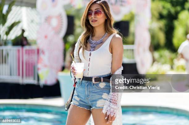 Aditi Oberoi Malhorta wearing Lous Vuitton backpack, denim shorts, white top at the Revovle Festival during day 3 of the 2017 Coachella Valley Music...
