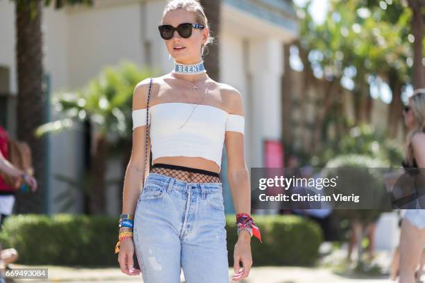 Sabrina Berner wearing a white off shoulder top, fishnet tights, denim jeans at the Revovle Festival during day 3 of the 2017 Coachella Valley Music...