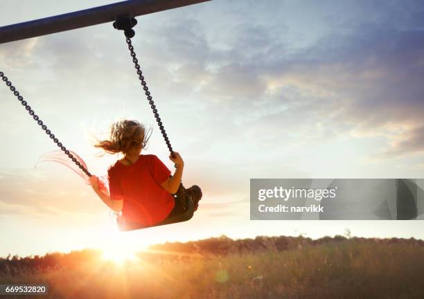 niña disfrutando de balanceo - see saw fotografías e imágenes de stock