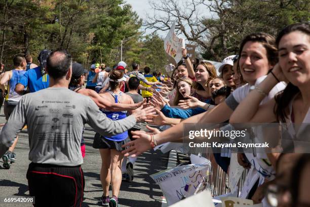 Crowds cheer on Boston Marathon runners in the iconic "scream tunnel" near Wellesley College on April 17 in Wellesley Massachusetts.