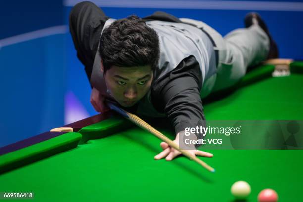 Yan Bingtao of China plays a shot during his first round match against Shaun Murphy of England on day three of Betfred World Championship 2017 at...