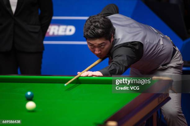Yan Bingtao of China plays a shot during his first round match against Shaun Murphy of England on day three of Betfred World Championship 2017 at...