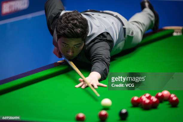 Yan Bingtao of China plays a shot during his first round match against Shaun Murphy of England on day three of Betfred World Championship 2017 at...