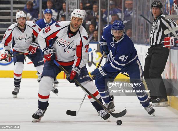 Daniel Winnik of the Washington Capitals skates with the puck against Nazem Kadri of the Toronto Maple Leafs in Game Three of the Eastern Conference...