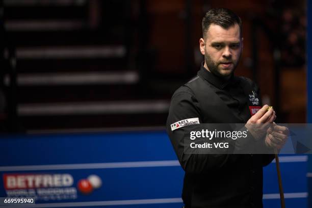 Jimmy Robertson of England chalks the cue during his first round match against Mark Allen of Northern Ireland on day three of Betfred World...