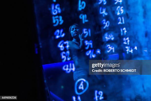 This photo taken on March 29, 2017 shows a pole dancer's reflection on a board with numbers assigned to dancers at a go-go bar in Walking Street, a...