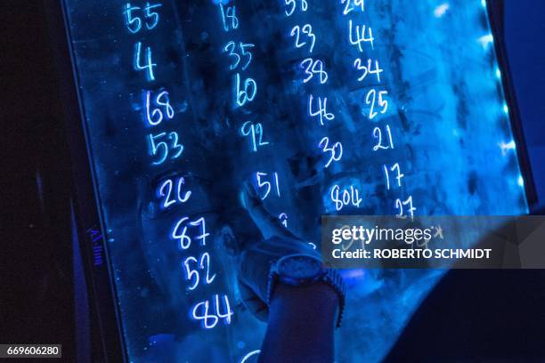 This photo taken on March 29, 2017 shows a bar supervisor checking on numbers assigned to pole dancers for rotations at a go go bar in Walking Street...