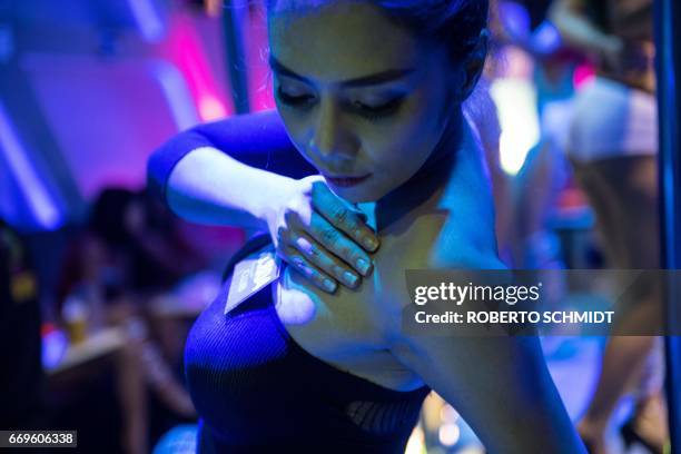 This photo taken on March 29, 2017 shows a go go dancer performing on a stage at dance bar in Walking Street in Pattaya. Two hours east of Bangkok,...