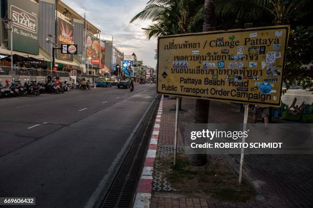 This photo taken on March 29, 2017 shows a road sign announcing a public transport order campaign covered with stickers, along Beach Road in Pattaya....
