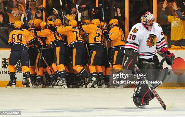 Kevin Fiala of the Nashville Predators is swarmed by teammates after scoring the game winning overtime goal against goalie Corey Crawford of the...