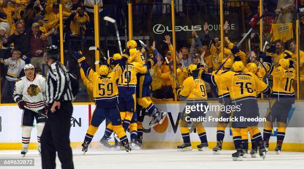 The Nashville Predators charge the ice after defeating the Chicago Blackhawks in overtime in Game Three of the Western Conference First Round during...