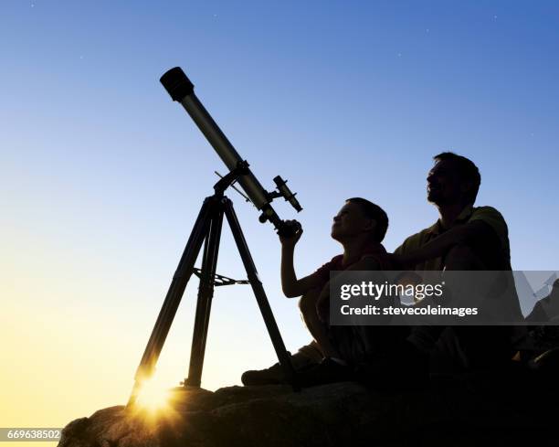 father and son with telescope - kids astronomy stock pictures, royalty-free photos & images